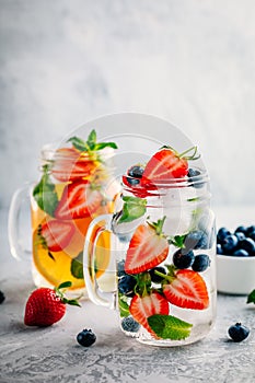 Infused detox water with blueberry, strawberry, orange and mint. Ice cold summer cocktail or lemonade.