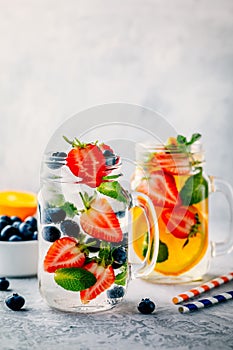 Infused detox water with blueberry, strawberry, orange and mint. Ice cold summer cocktail or lemonade.