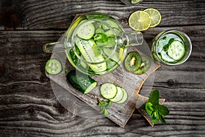 Infused detox water with cucumber, lemon, kiwi and mint for diet healthy eating and weight loss with copy space. overhead view