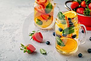 Infused detox water with orange, blueberry, strawberry and mint. Ice cold summer cocktail or lemonade.