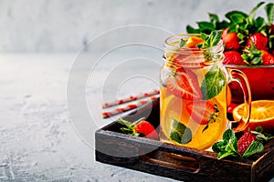 Infused detox water with orange, strawberry and mint. Ice cold summer cocktail or lemonade.