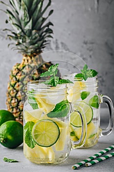 Infused detox water with pineapple, lime and mint. Ice cold summer cocktail or lemonade