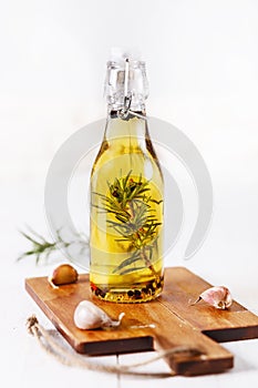 Infused olive oil over white wooden background