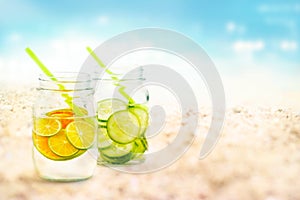 Infused water lemon and cucumber in mug on sea sand beach summer day and nature background