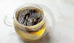 Infusing herbal tea in glass mug on marble table