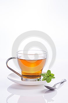Infusion of peppermint in crystal glass and fresh mint leaves, isolated on white background