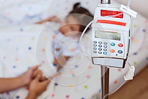 Infusion pump feeding IV drip into child patient photo