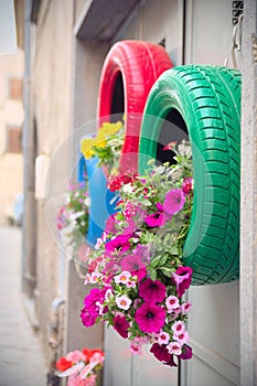 Ingenious, original and environmentally friendly method of recycling of tires car as planters (detail of the red and green)