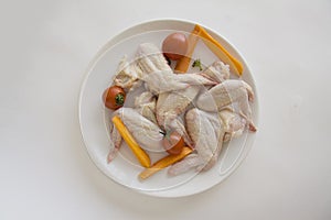 Ingerdients for barbecue: chicken wings and vegetables