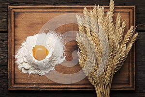 Ingredients for baking bread and bread ears on a wooden vintage background,