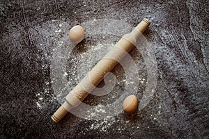 Ingredients for baking bread, eggs, rolling pin lie on a gray table