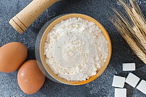 Ingredients for baking a cake at home. Flour and sugar, eggs with butter, spices on a dark brutal table Selective focus