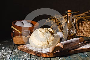 Ingredients for baking croissants - flour, wooden spoon, rolling pin, eggs, egg yolks, butter served on wooden background