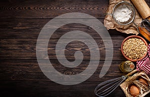 Ingredients for baking on empty dark wooden background