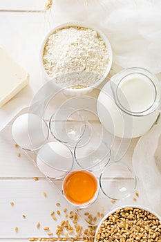 Ingredients for baking: flour, milk, wheat grain, butter and eggs