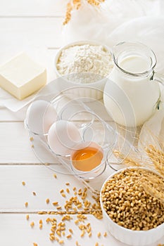 Ingredients for baking: flour, milk, wheat grain, butter and eggs