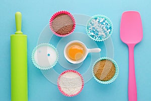 Ingredients for baking and kitchen tools on blue background, flat lay