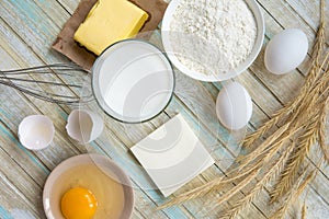 Ingredients for baking: milk, flour, egg and butter top view