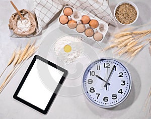 Ingredients for baking with tablet and clock