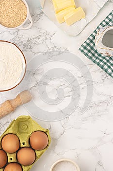 Ingredients and baking utensils for cooking tart, cookies, pastry. Flat lay with eggs, flour, butter, brown sugar, water, salt.