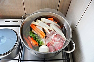 Ingredients for beef soup in pot. Meat, fresh vegetables and herbs prepared for cooking beef soup