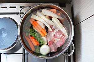 Ingredients for beef soup in pot. Meat, fresh vegetables and herbs prepared for cooking beef soup. Top view