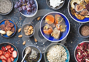 Ingredients in bowls for healthy breakfast over dark blue background