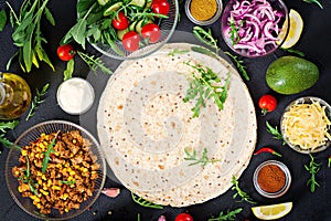 Ingredients for burritos wraps with beef and vegetables on black background