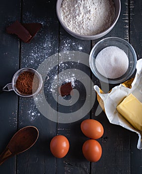 Ingredients for chocolate brownies on dark background, top view