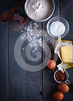 Ingredients for chocolate brownies on dark background, top view