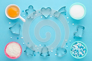 Ingredients and cookie cutter on blue background, flat lay