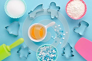 Ingredients and cookie cutter on blue background, flat lay