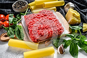 Ingredients for cooking cannelloni pasta with ground beef. Italian cuisine. Gray background. top view