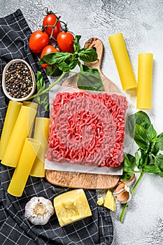 Ingredients for cooking cannelloni pasta with ground beef. Italian cuisine. Gray background. top view
