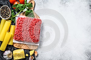 Ingredients for cooking cannelloni pasta with ground beef. Italian cuisine. Gray background. top view. Copy space