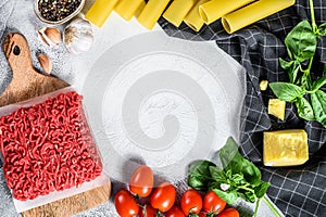 Ingredients for cooking cannelloni pasta with ground beef. Italian cuisine. Gray background. top view. Copy space