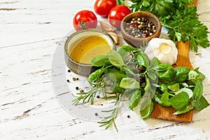 Herbs spices, olive oil and vegetables on a wooden table. Copy space