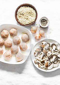 Ingredients for cooking orzo mushrooms pasta with teriyaki sauce chicken roasted meatballs on a light background, top view