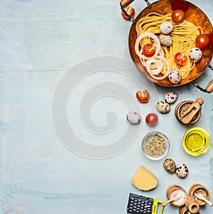 Ingredients for cooking pasta with quail eggs and parmesan cheese and cherry tomatoes, and spices and oil on wooden rustic backgro