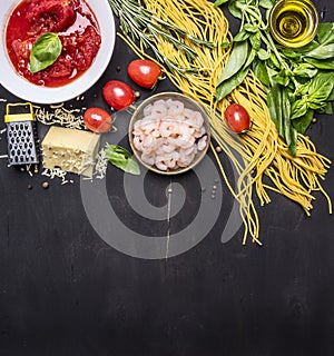 Ingredients for cooking pasta with shrimp, herbs, tomatoes, cheese, tomatoes in own juice border, place for text on wooden rustic