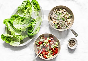 Ingredients for cooking - romaine salad and tuna, egg, tomato, avocado salad on a light background, top view. Delicious appetizer