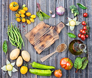 Ingredients for cooking on rustic wooden table around empty cutt