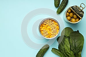 Ingredients for cooking salad with canned corn and olives on blue background