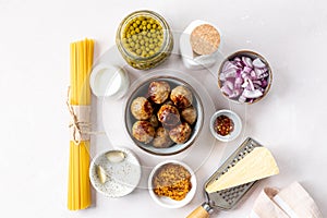 Ingredients for cooking spaghetti pasta with meatballs in cream sauce.