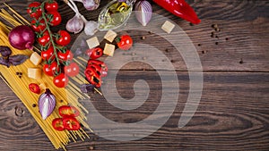 Ingredients for cooking spaghetti - raw pasta, tomato, olive oil, spices, herbs