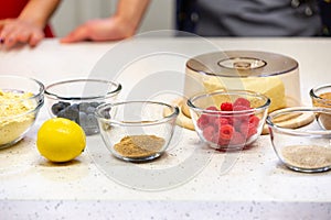 Ingredients for cooking strawberry pie or cake on white background. Side view. Flour, milk, sugar, strawberry, lemon
