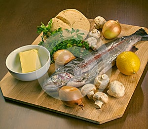 Ingredients for cooking stuffed fish mushrooms onion salad butter bread