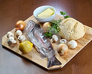 Ingredients for cooking stuffed fish mushrooms onion salad butter bread