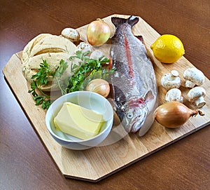 Ingredients for cooking stuffed fish mushrooms onion salad butter bread