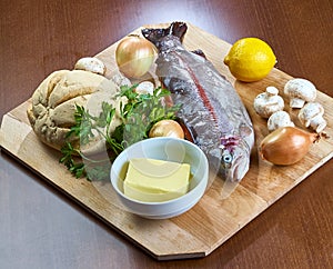 Ingredients for cooking stuffed fish mushrooms onion salad butter bread